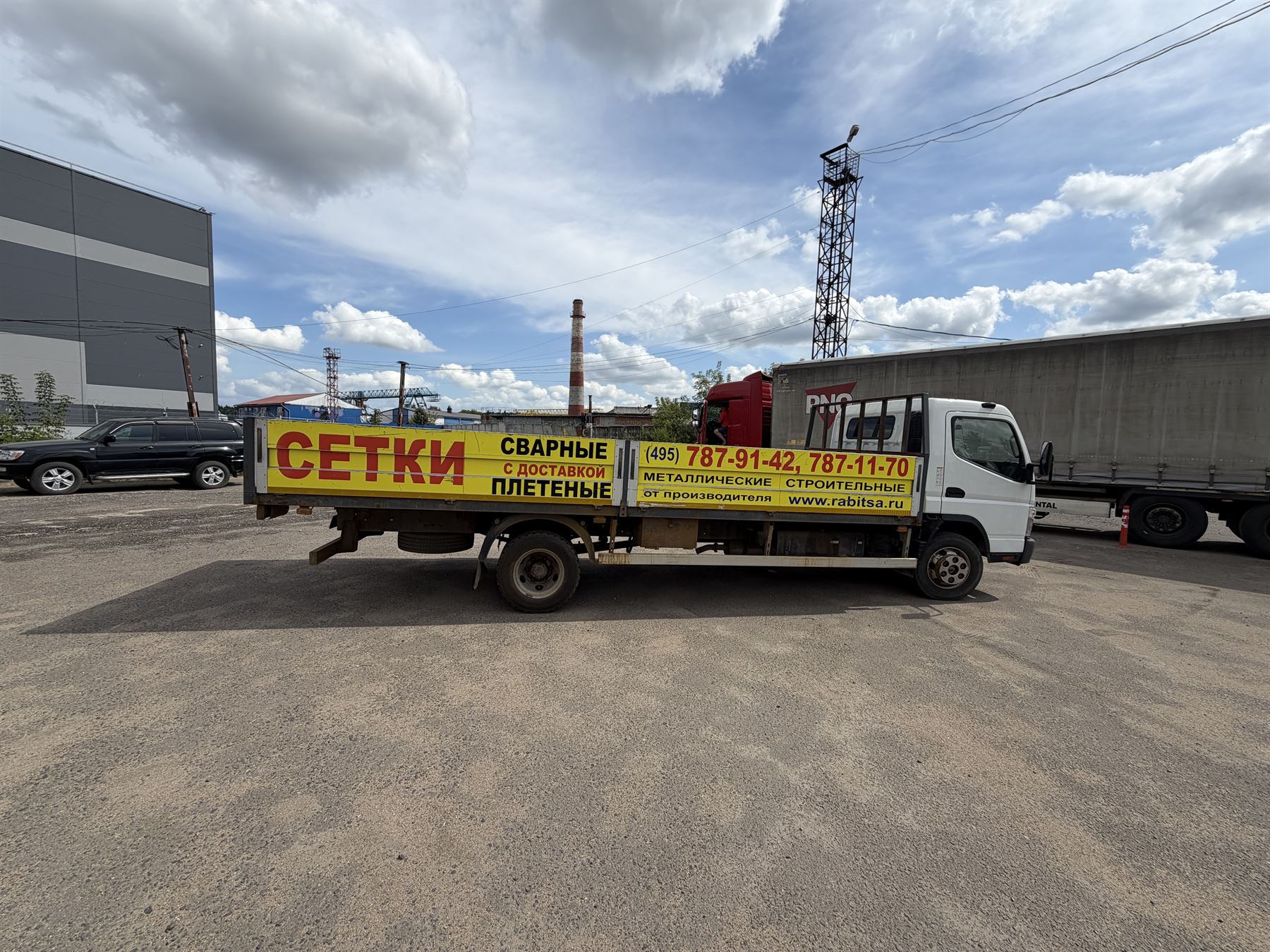 Бортовой Mitsubishi Fuso 5,5 т с рекламой «Сетки сварные плетёные» и телефонами завода